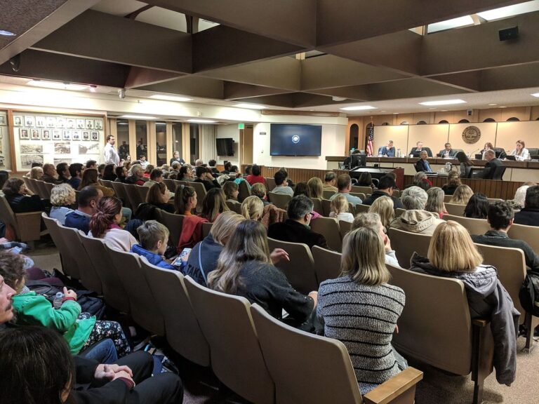 Residents fill the seats at a city planning commission meeting while commissioners sit at the dais